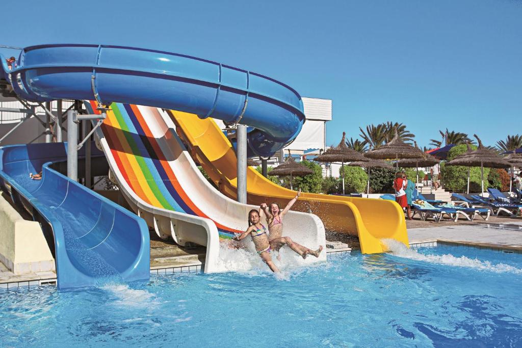 een vrouw glijdt over een waterglijbaan in een resort bij El Mehdi Beach Resort ex Primasol El Mehdi in Mahdia