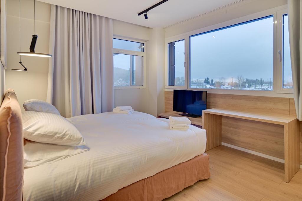 a bedroom with a large bed and a large window at Nomads Lux Studios & Business Center in Ioannina