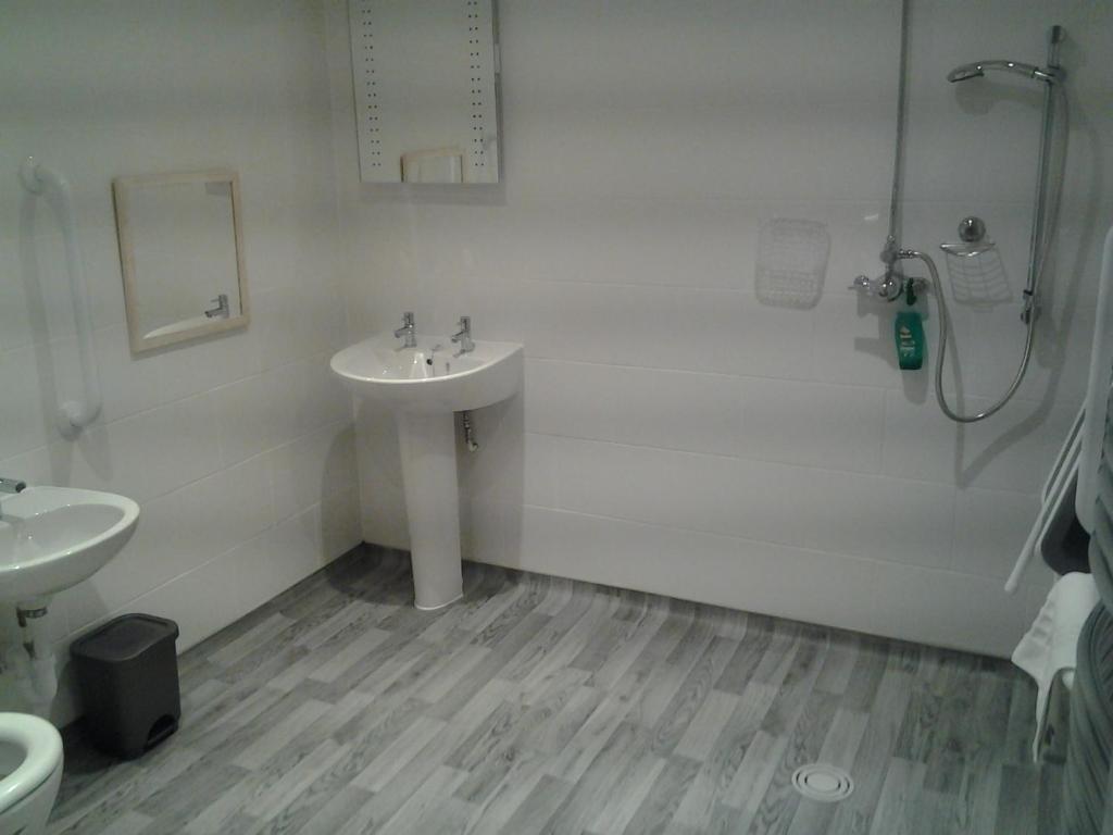 La salle de bains est pourvue d'un lavabo et d'une douche. dans l'établissement The Green Dragon, à Market Lavington