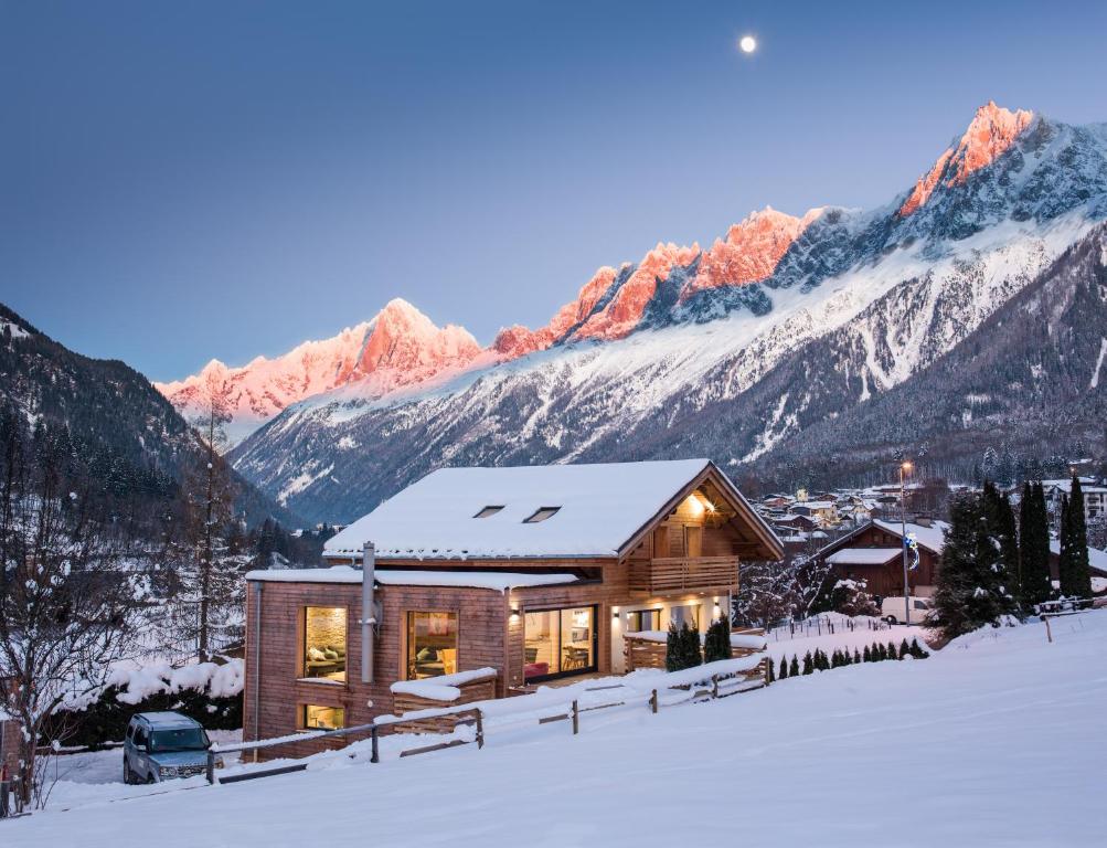 una casa en la nieve con montañas en el fondo en Chalet Rubicon en Les Houches