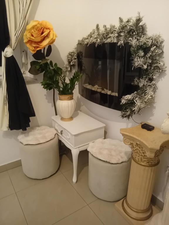 a room with two stools and a table with a vase at Apartment Top Centar in Banja Luka