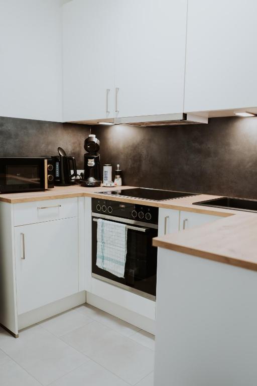 a kitchen with white cabinets and an oven at Moderne Wohnung in Dernbach WW in Dernbach