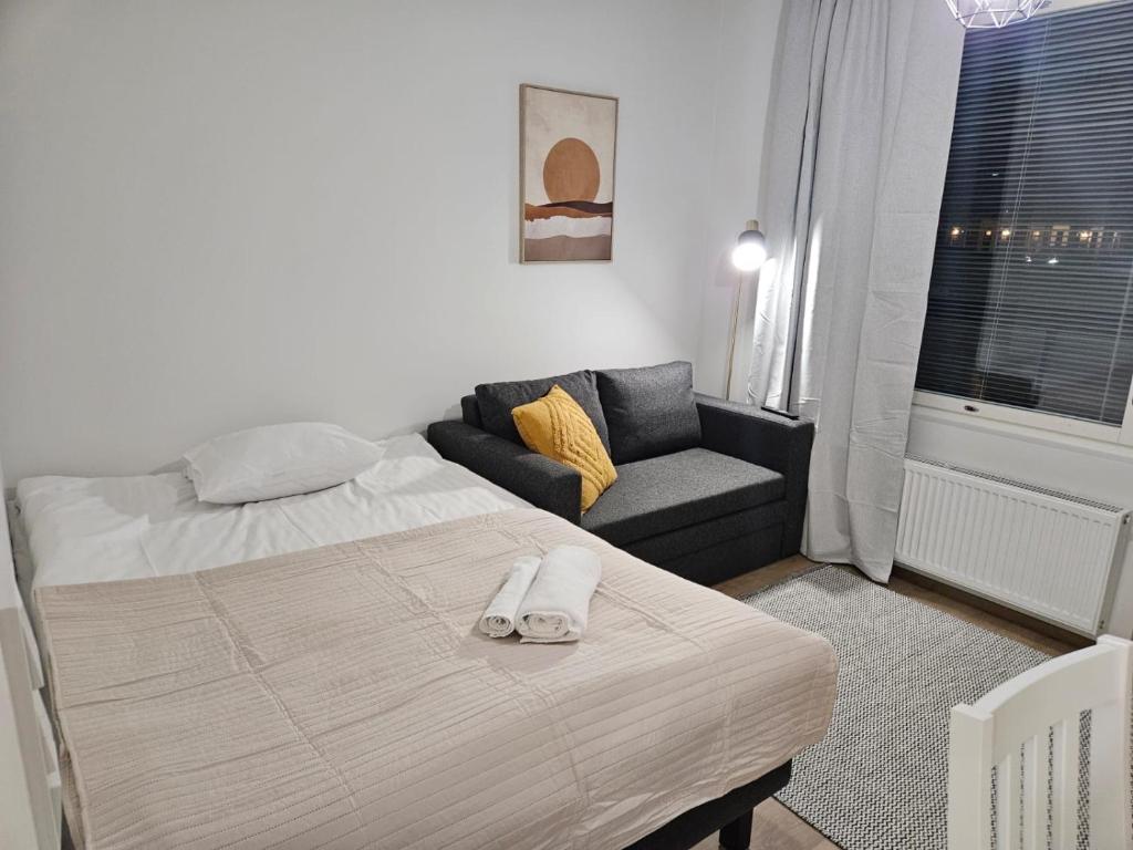 a bedroom with a bed and a couch at Studio Apartment Aurora in Rovaniemi