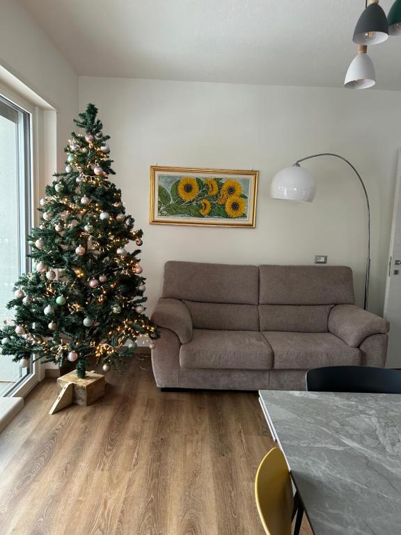 a living room with a christmas tree and a couch at Nuovo appartamento affitto in Cavareno