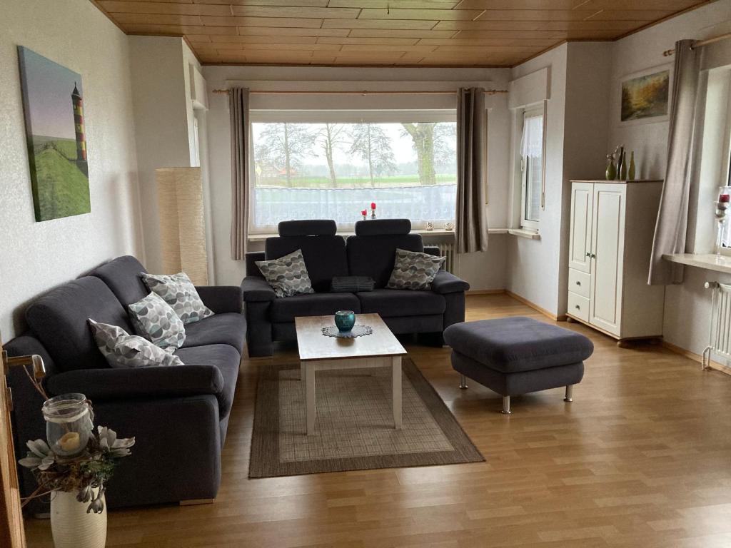 a living room with a couch and a table at Ferienhaus Großheider Straße in Großheide