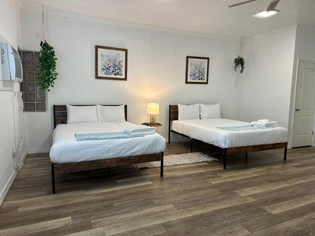克利尔沃特2q Beds Studio Apt With Shared Pool 18的两张床在铺有木地板的房间里