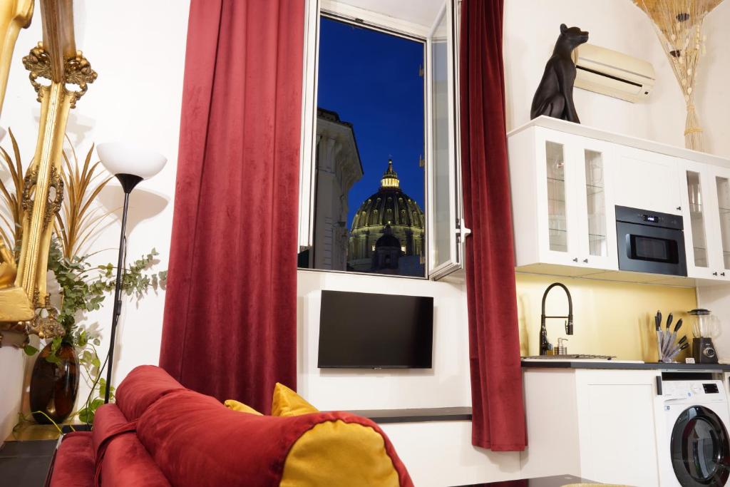 a living room with a red couch and a window at THE GRAND VIEW Lux Vatican Suite in Rome