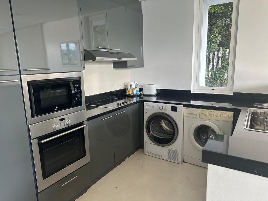 a kitchen with a washing machine and a washer and dryer at Jirana Patong in Patong Beach