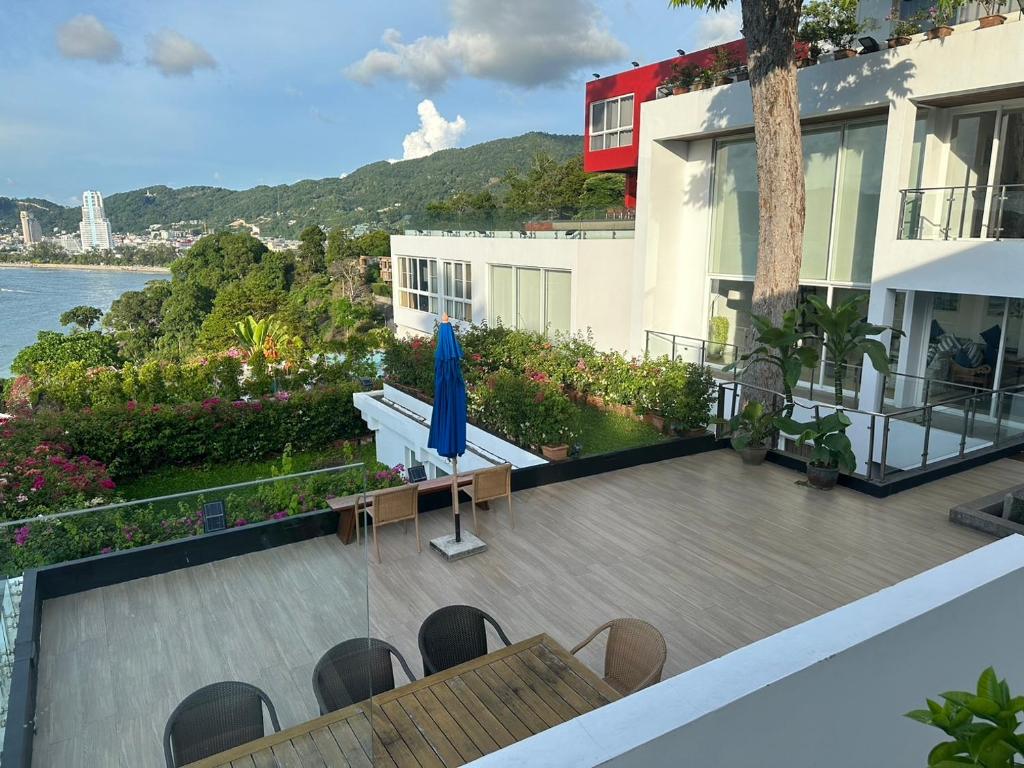 a balcony of a building with a blue umbrella at Jirana Patong in Patong Beach