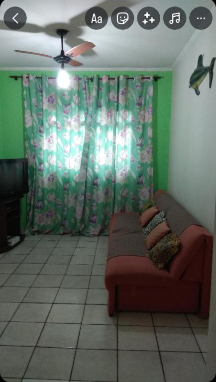 a living room with a couch and a ceiling fan at Apartamento na praia grande in Praia Grande