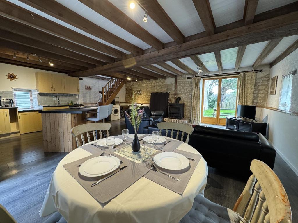 a dining room with a table and a kitchen at La Grange D'EsusTerra - Piscine - 6 pers - Rêve au Mans in Aubigné-Racan