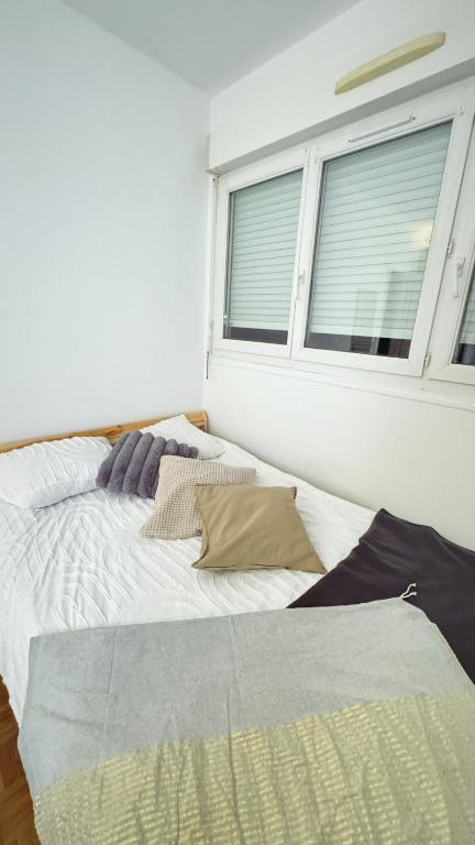 un lit dans une chambre avec une fenêtre dans l'établissement Cosy nest, à Aubergenville