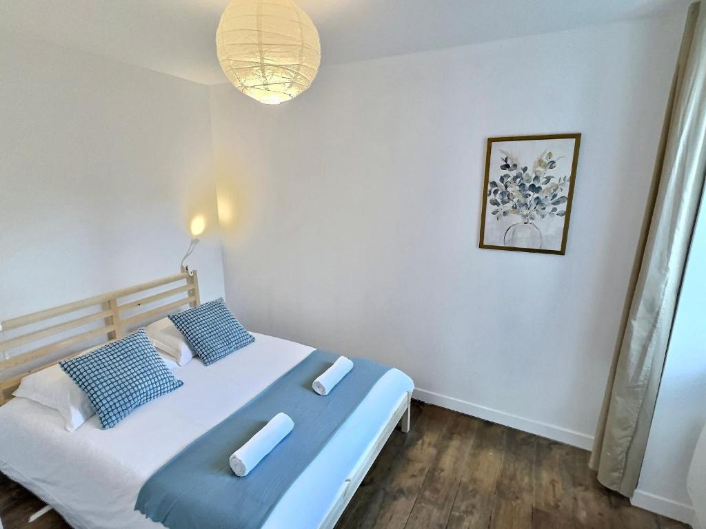 une chambre avec un lit avec des oreillers bleus et blancs dans l'établissement Wonderhost, Central Avenue en coeur de ville, à Pau