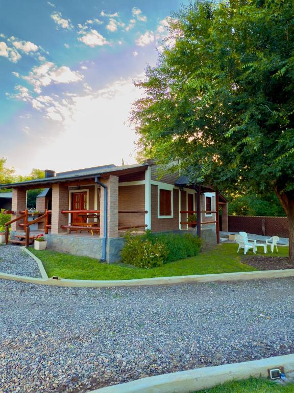 a house with a gravel driveway in front of it at Complejo Entre Olmos in Santa Rosa de Calamuchita