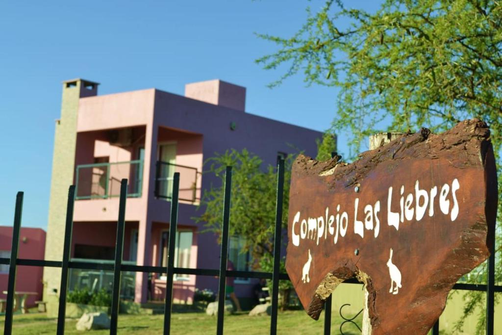 ein Schild auf einem Zaun vor einem Gebäude in der Unterkunft Complejo Las Liebres in San Lorenzo