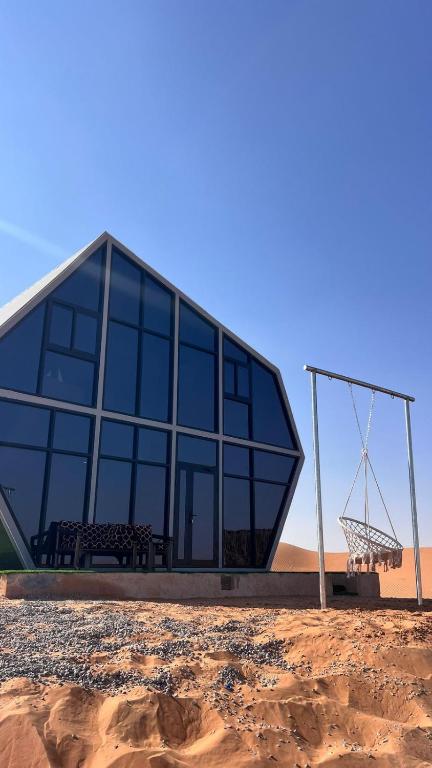 a glass building with a bench and a basketball hoop at Moon Light Camp in Bidiyah