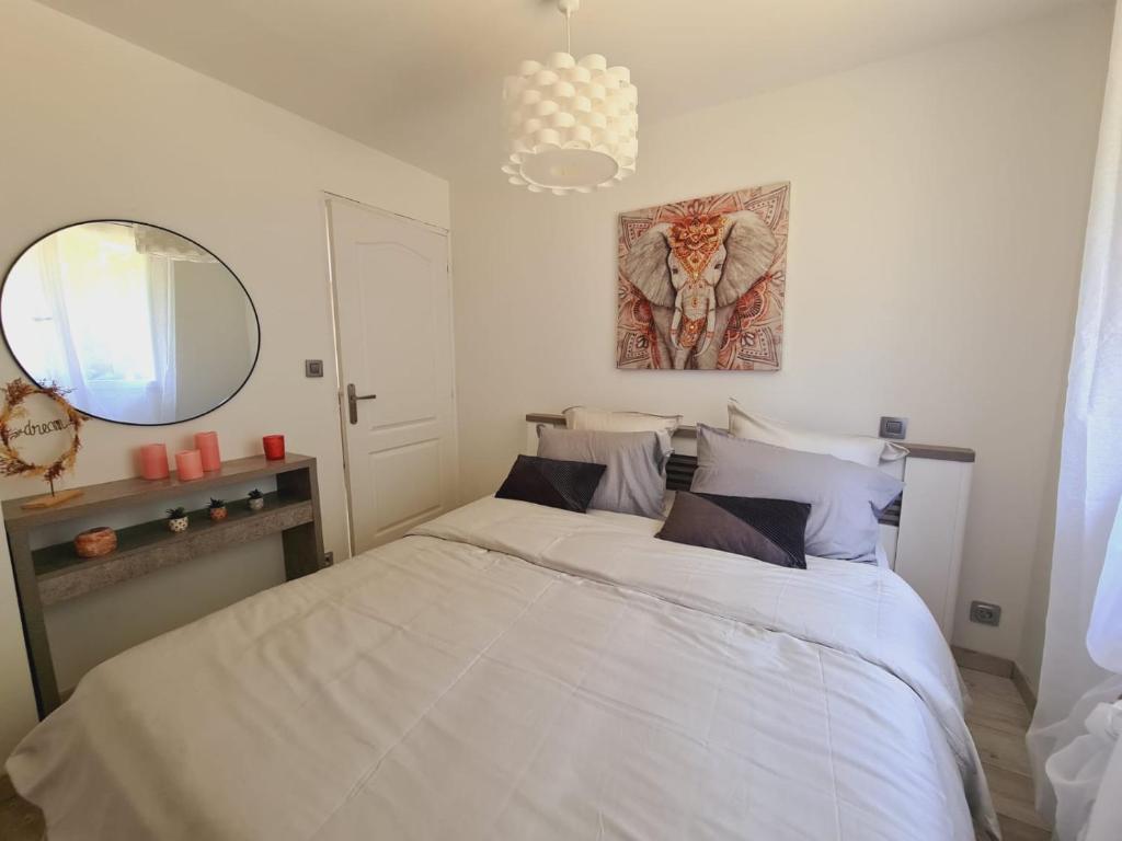 a bedroom with a white bed and a mirror at L'Échappée Belle près de Toulouse in Castelnau-dʼEstrétefonds
