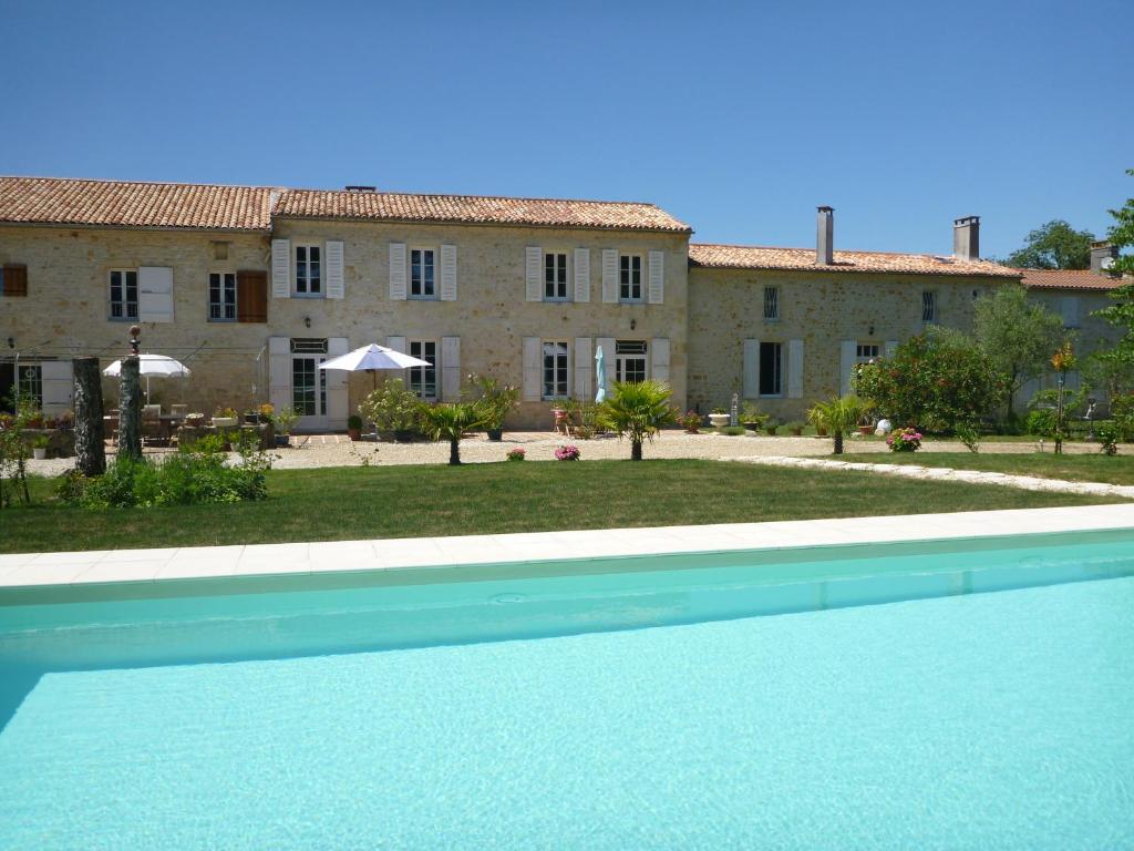 una vista de una casa y una piscina frente a un edificio en Domaine du Papillon, en Lesparre-Médoc