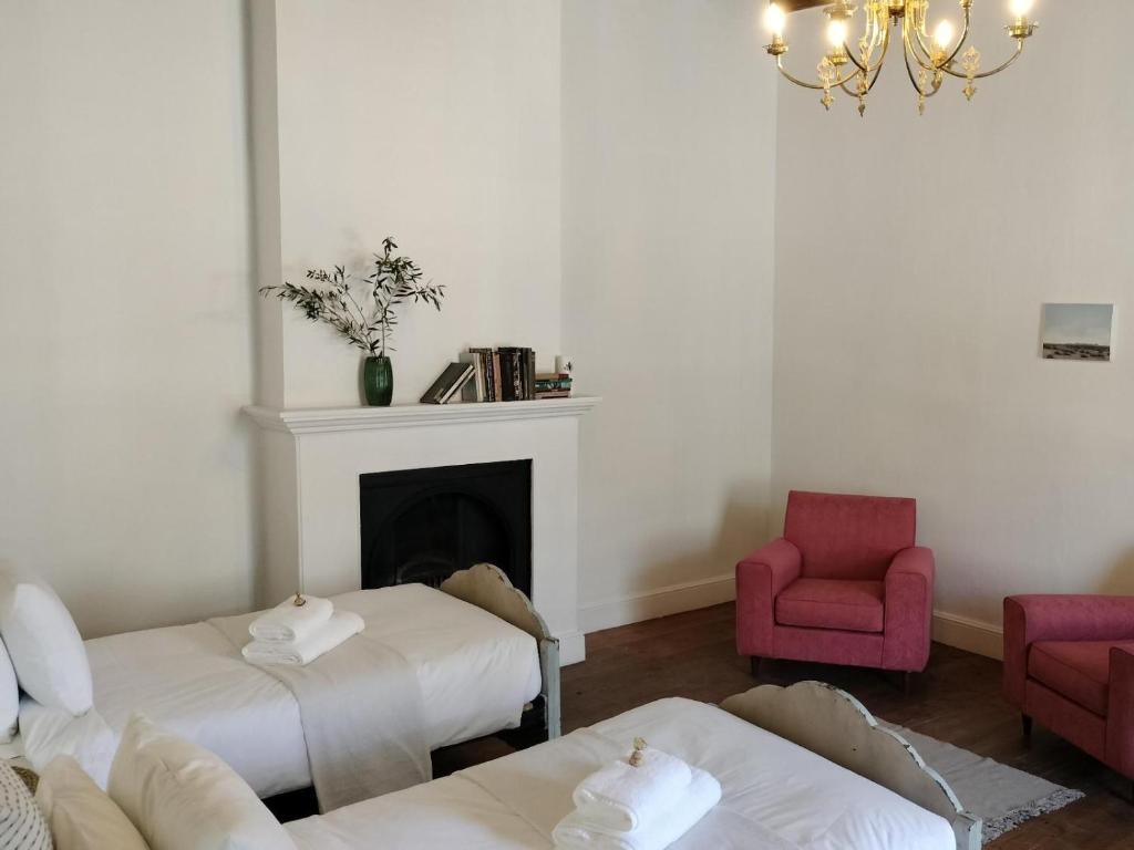 a living room with two beds and a fireplace at Rusgenot - Richmond, Karoo in Richmond