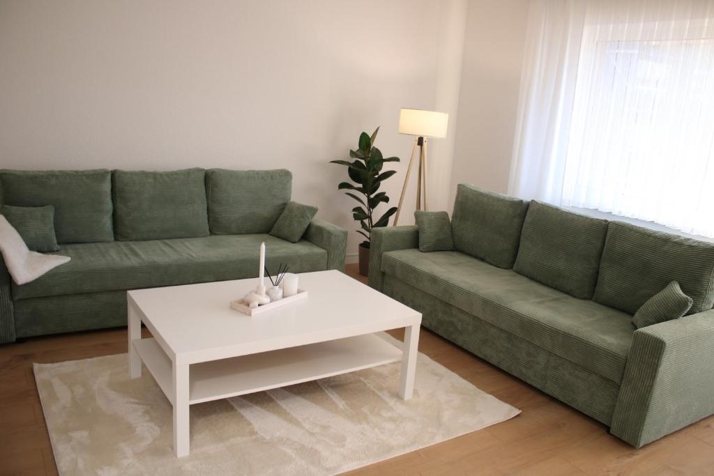een woonkamer met twee banken en een salontafel bij Apartment auf Schalke in Gelsenkirchen