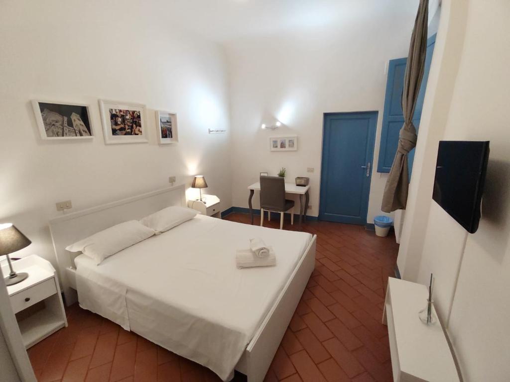 a small bedroom with a white bed and a table at Michelangelo's Relais in Florence