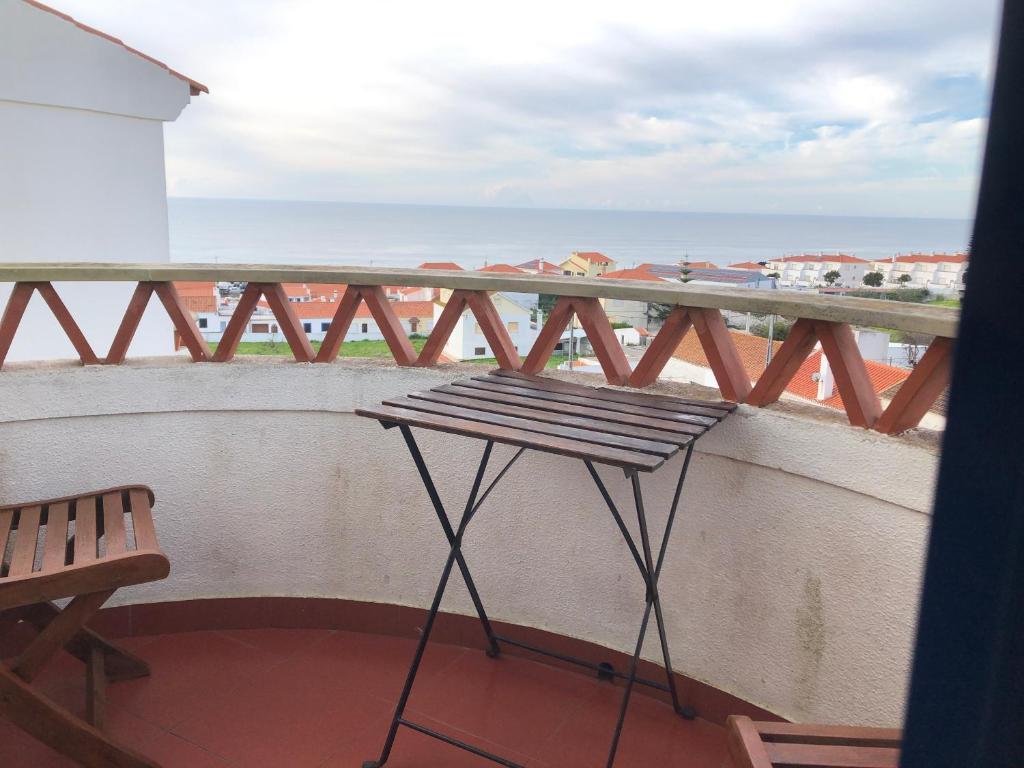 a bench on a balcony with a view of the ocean at Casa das Conchas in Ericeira