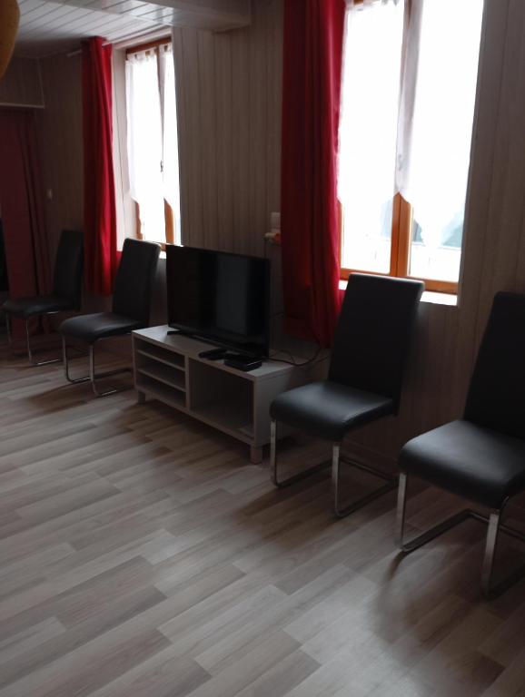 une salle d'attente avec des chaises et une télévision à écran plat dans l'établissement Martinique, à Mont-dʼOrigny