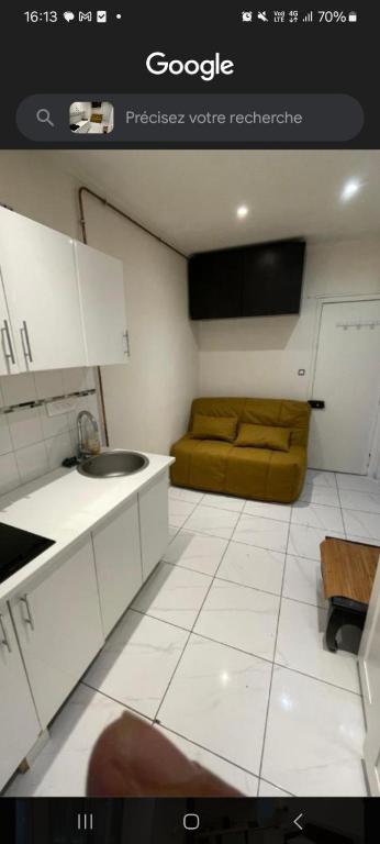 une cuisine avec un évier et un canapé dans une chambre dans l'établissement Chambre proche centre et monuments, à Paris