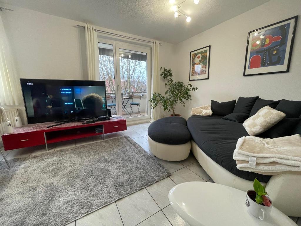 a living room with a couch and a flat screen tv at BEIMS APARTMENT-Vollausstattung-Küche, kostenlos-WFI, Smart-TV in Magdeburg