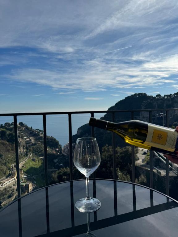 a bottle of wine and a wine glass on a table at Voce del Mare Apartment in Pontone
