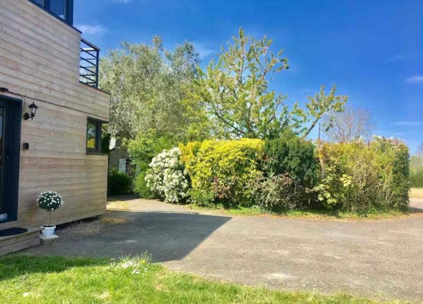 une maison avec un tas de buissons à côté d'un bâtiment dans l'établissement Cottage balnéo vue mer, à Bazenville