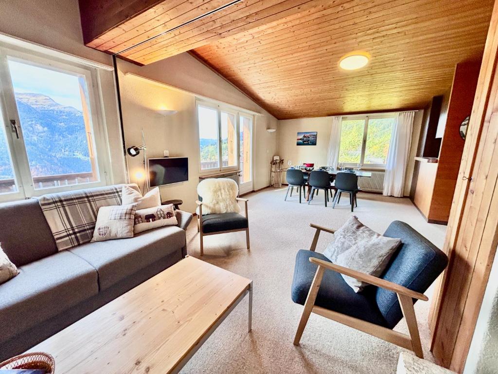 翁根Jungfraujoch, Chalet Ski In&Out, Wengen, Valley view的带沙发、椅子和桌子的客厅