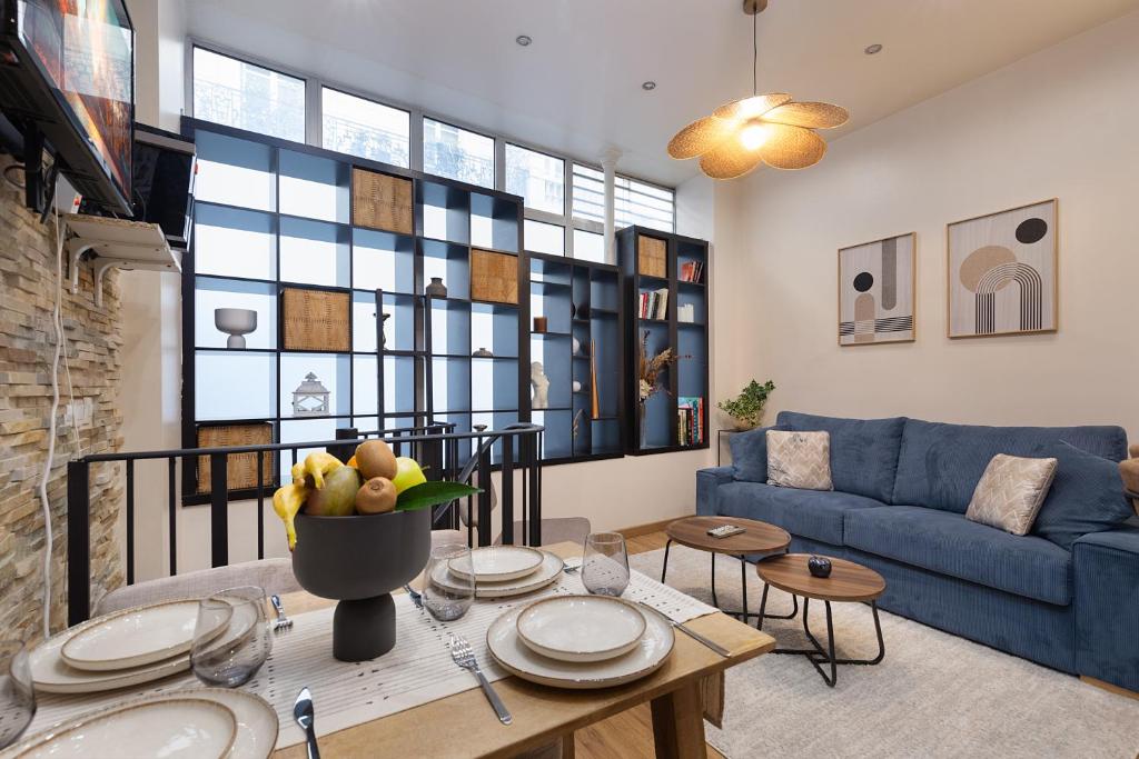 un salon avec un canapé bleu et une table dans l'établissement charmant et chaleureux paris 17ème, à Paris