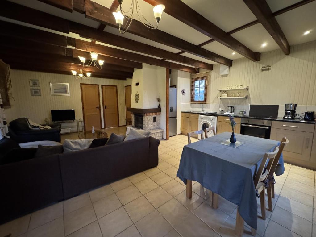 a living room with a table and a couch at Le Chalet D'EsusTerra - 4pers - Rêve au Mans in Aubigné-Racan