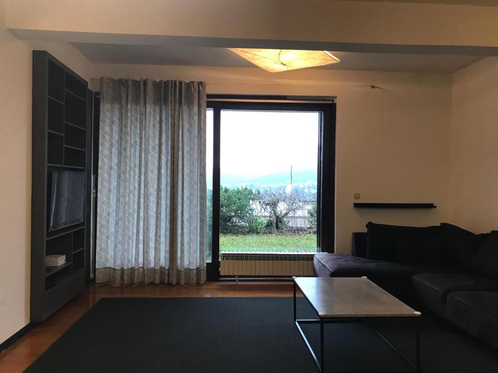 a living room with a couch and a large window at Guesthouse - Hotel California 2 in Zagreb