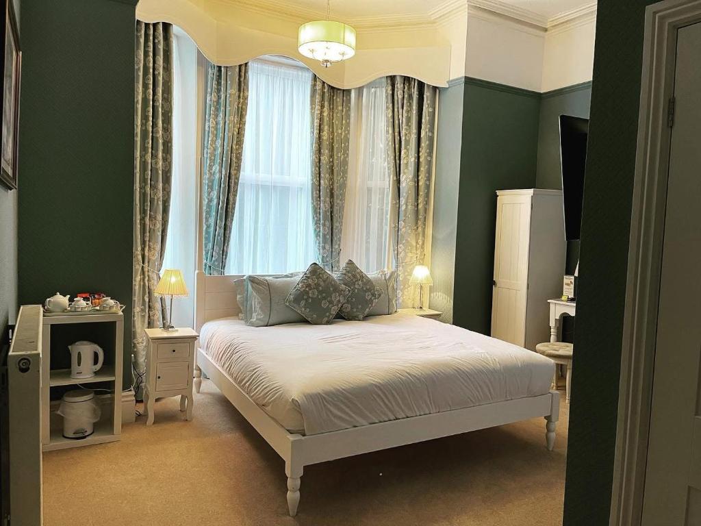 a bedroom with a large bed with a window at Balincourt in Bournemouth