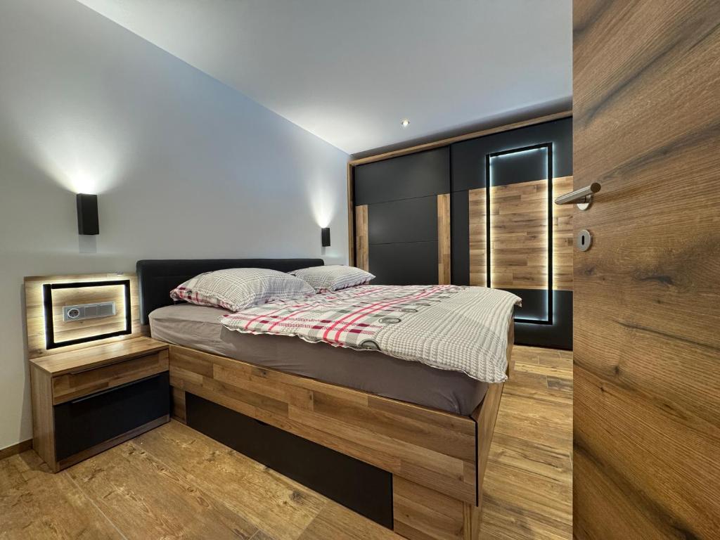 a bedroom with a bed with a wooden headboard at Feriendomizil Garber-Bründl in Oberau