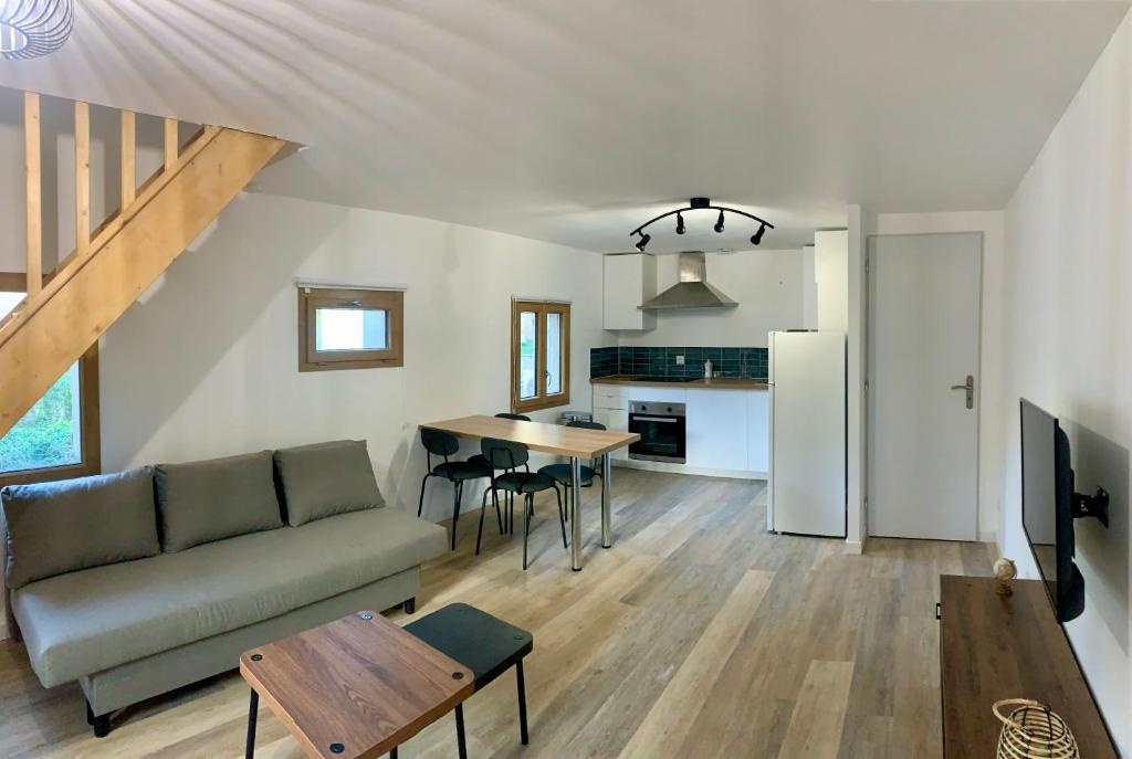 un salon et une cuisine avec un canapé et une table dans l'établissement La Reverie, au Thor
