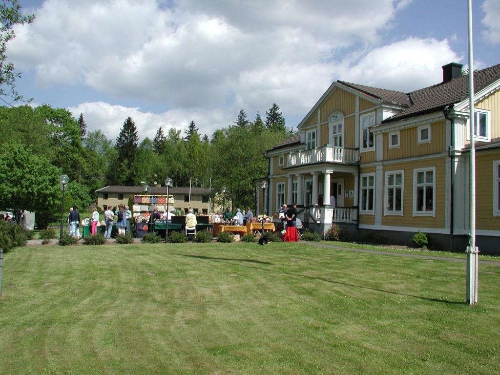 a group of people standing in front of a large house at Spånhults Herrgård Hostel in Norrahammar