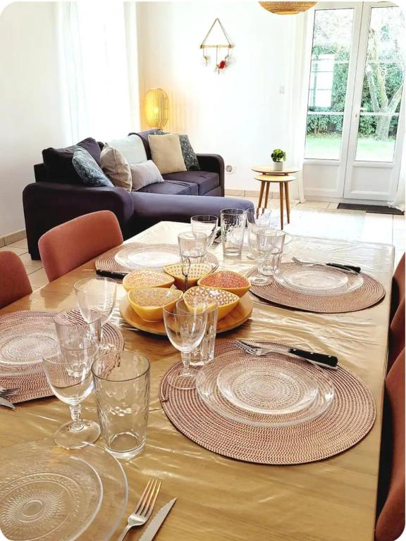 une table avec des assiettes et des verres au-dessus dans l'établissement Jolie maison lumineuse, à La Flotte