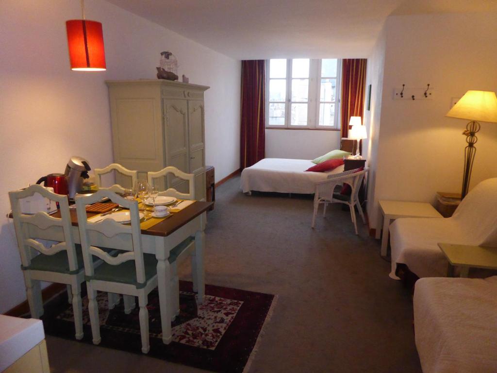 un salon avec un lit, une table et des chaises dans l'établissement Studio Lumineux, Coeur De Ville, à Dijon