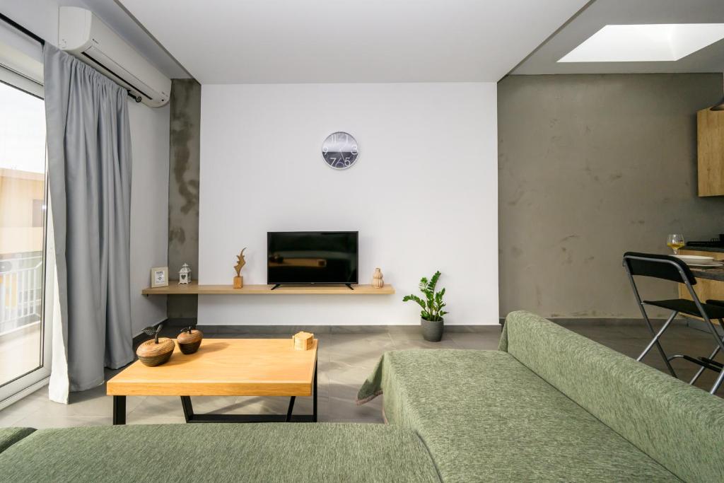 a living room with a green couch and a table at Modern Spacious Apartment in Kissamos