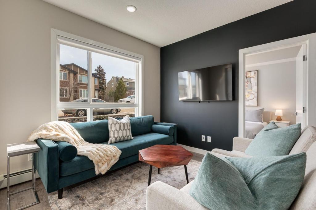 a living room with a blue couch and a window at Free Parking, Close to Downtown, Pet Friendly in Calgary