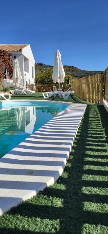 a pathway leading to a swimming pool with an umbrella at Casa de Andres in Casabermeja