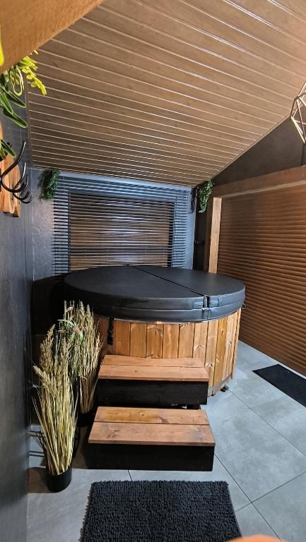a sauna with a bench and a large tub at Domki Spokojny Zakątek z balią z jacuzzi in Lipowa