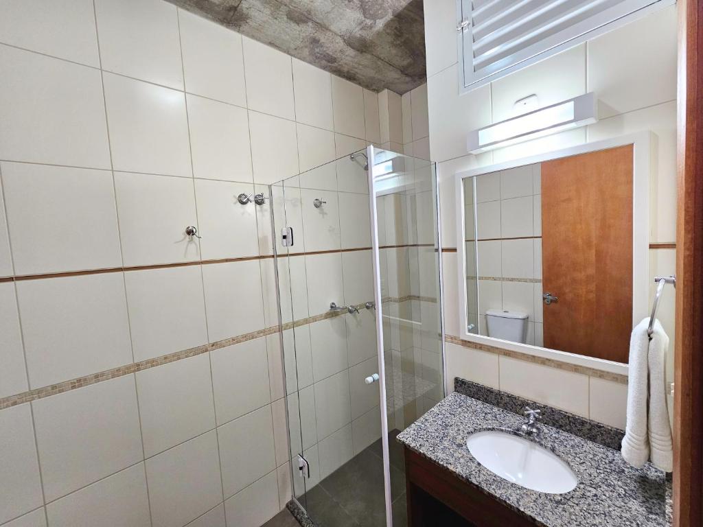 a bathroom with a sink and a mirror at Refúgio da Lagoinha - Centro de Bombinhas in Bombinhas