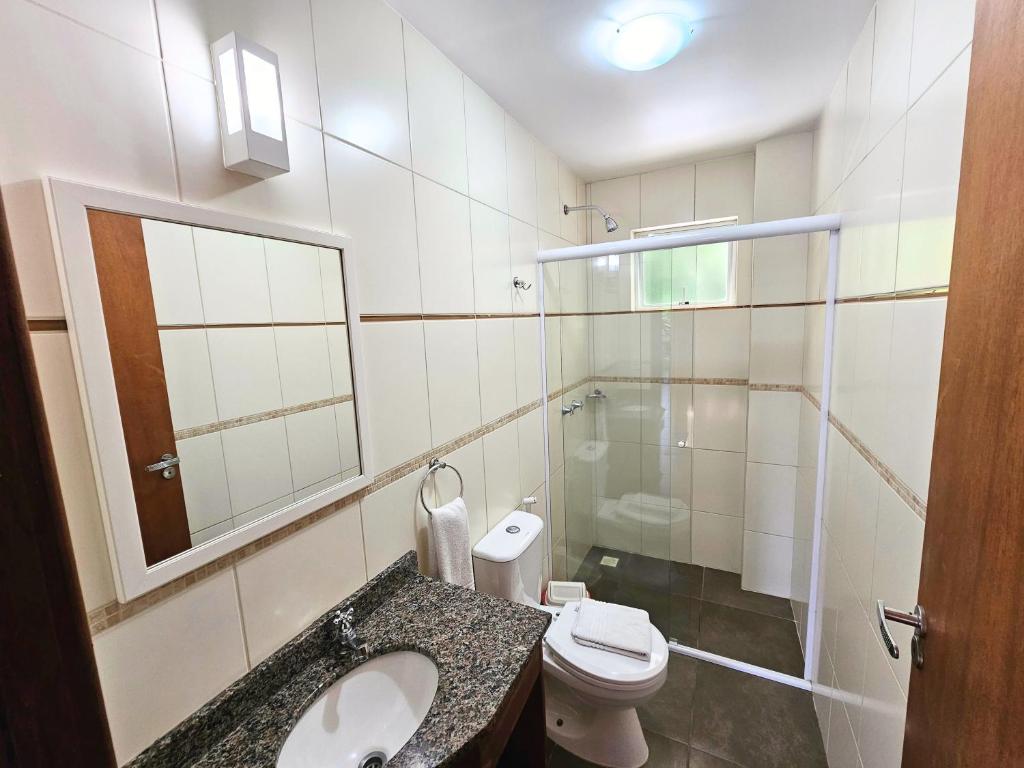 a bathroom with a toilet and a sink and a shower at Refúgio da Lagoinha - Centro de Bombinhas in Bombinhas