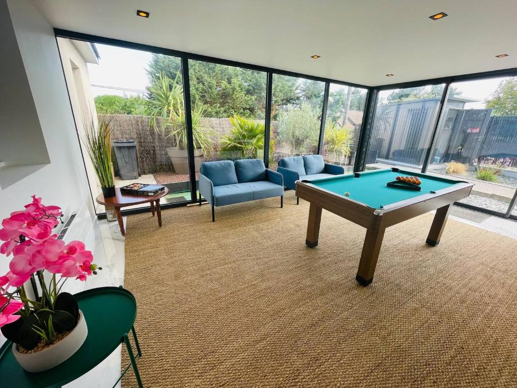 - un salon avec un billard au milieu dans l'établissement Villa avec Sauna & billard 6pers, à Blainville-sur-Mer