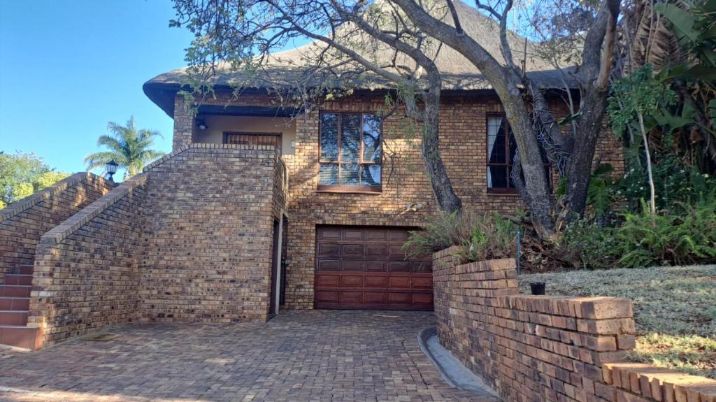 a brick house with a garage and a brick wall at Ithiliens Grace Guesthouse in Pretoria