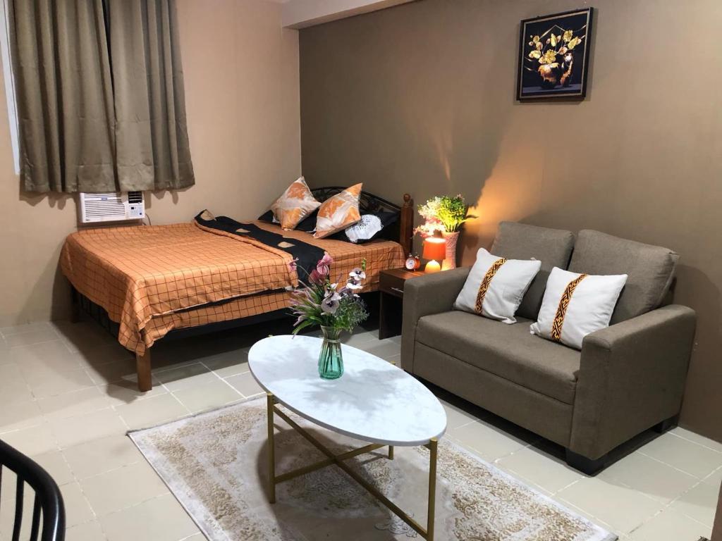 a living room with a bed and a couch at Belle Place at Saekyung Marigondon Building 203 unit 1303 in Lapu Lapu City